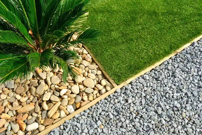 Modern garden with synthetic grass, river stones, and gravel